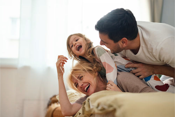 Family playing together on a bed
