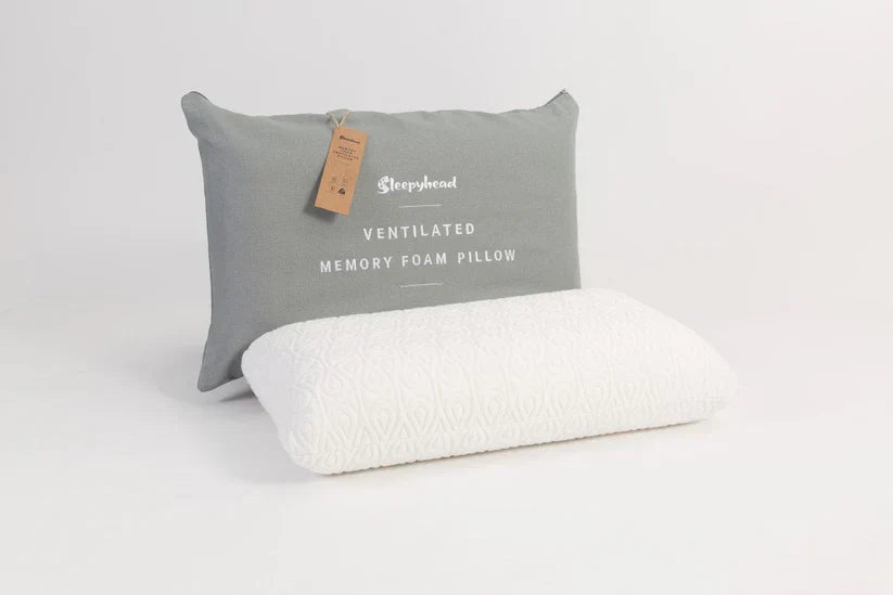 Grey pillow with a tag labeled 'Sleepyhead' on a white background