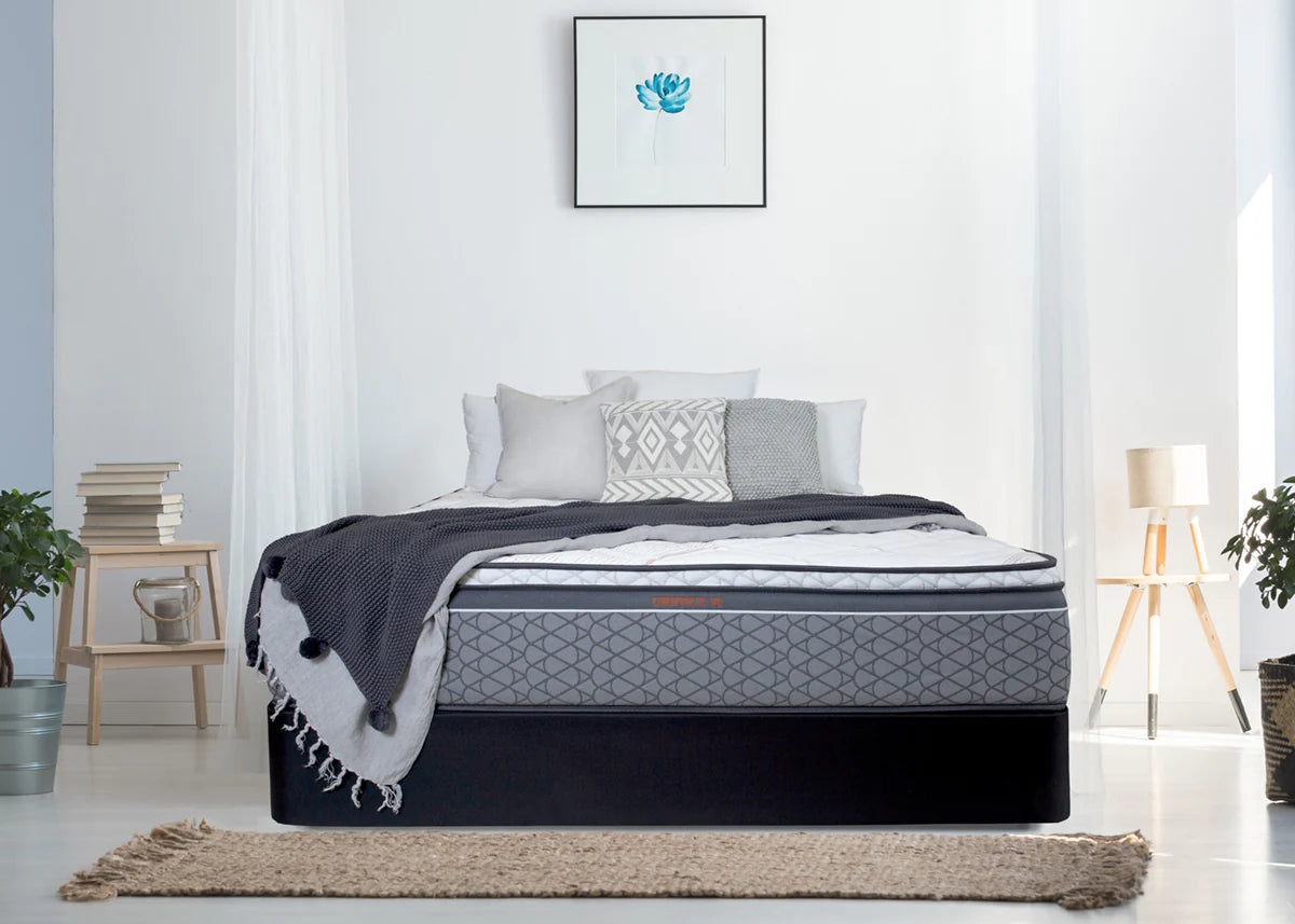 Sleepyhead Chiropractic bed with gray bedding and a blanket in a bright bedroom setting.