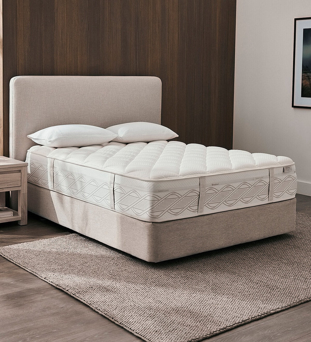 Sanctuary bed with white mattress and pillows in a room setting.