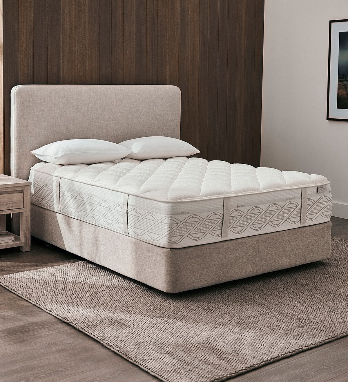 Sanctuary bed with white mattress and pillows in a room setting.