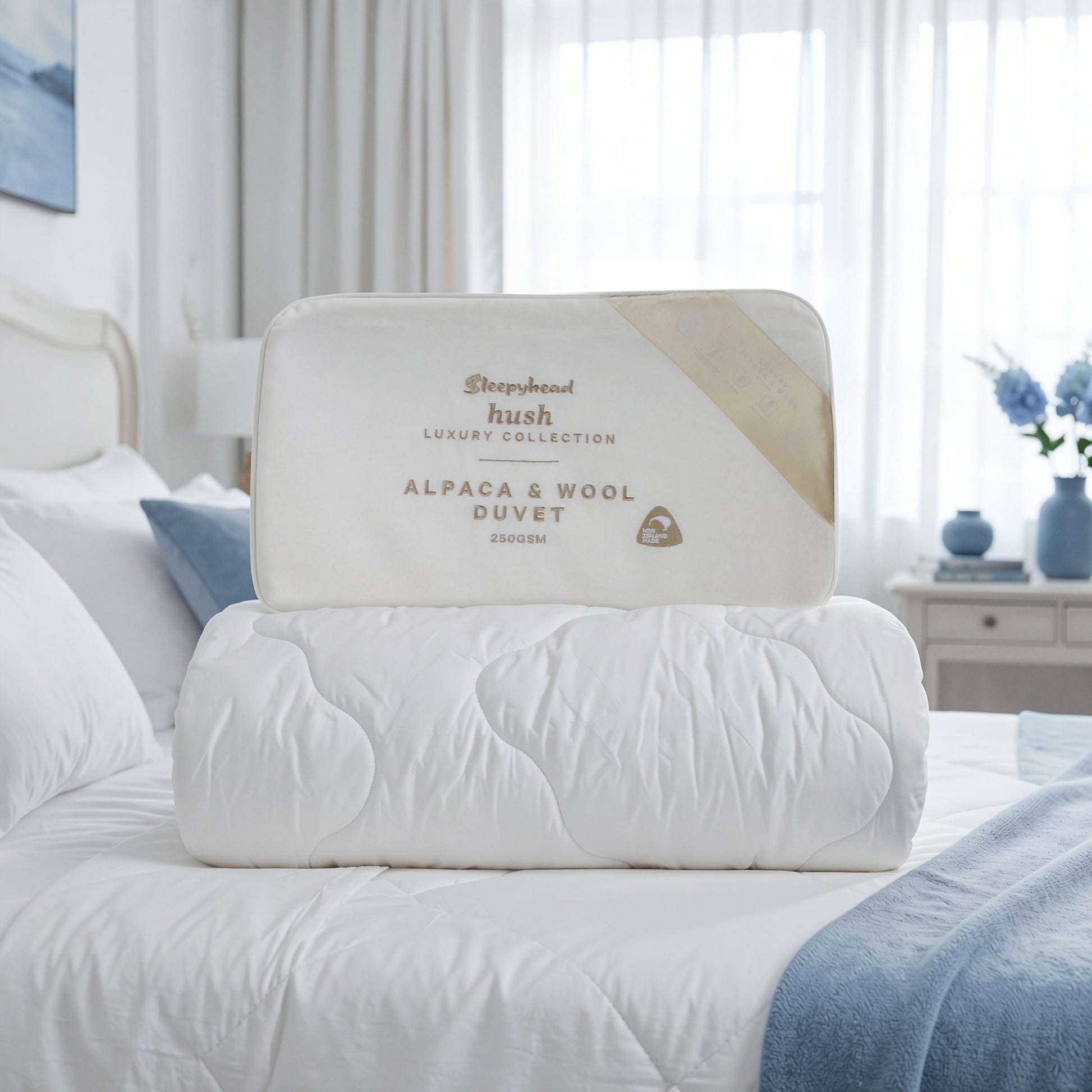 Alpaca and wool duvet on a bed with 'Sleepyhead Hush' branding.