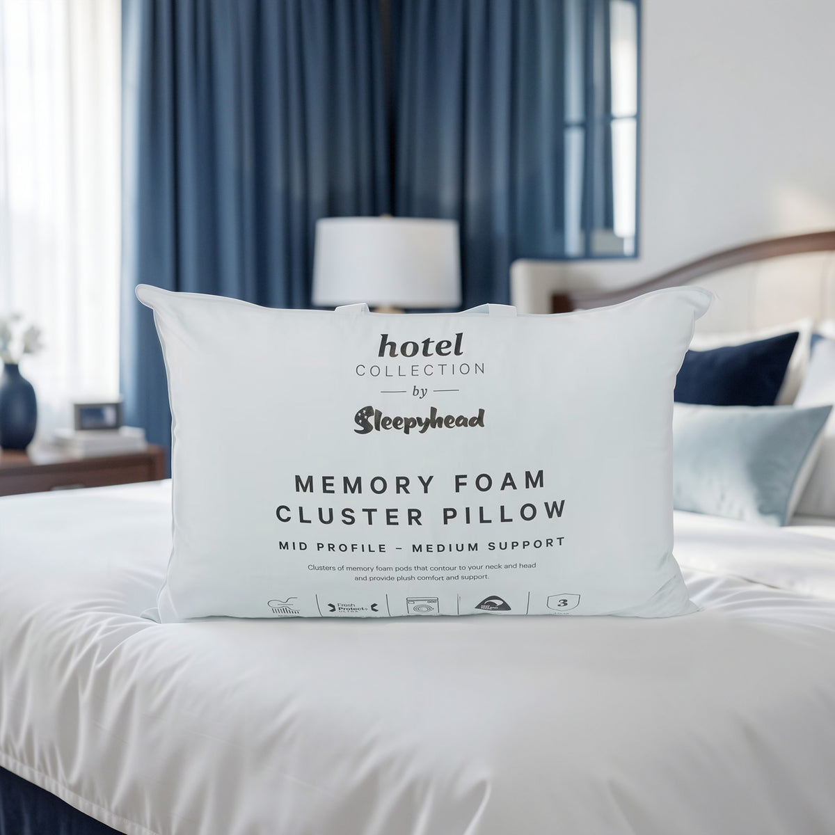 Memory foam cluster pillow by Sleepyhead on a bed with blue curtains in the background