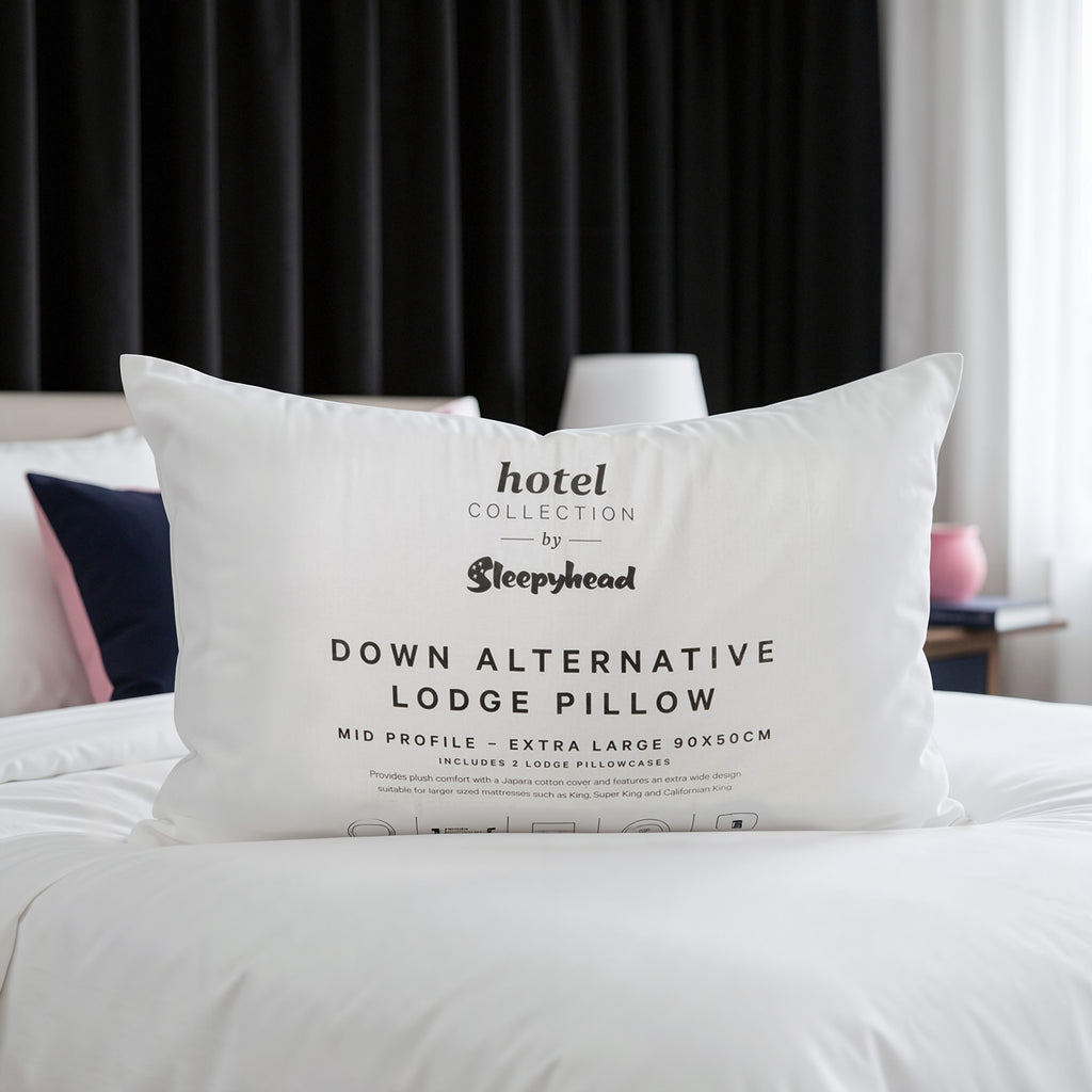 Down alternative lodge pillow with 'Hotel Collection by Sleepyhead' branding on a bed.