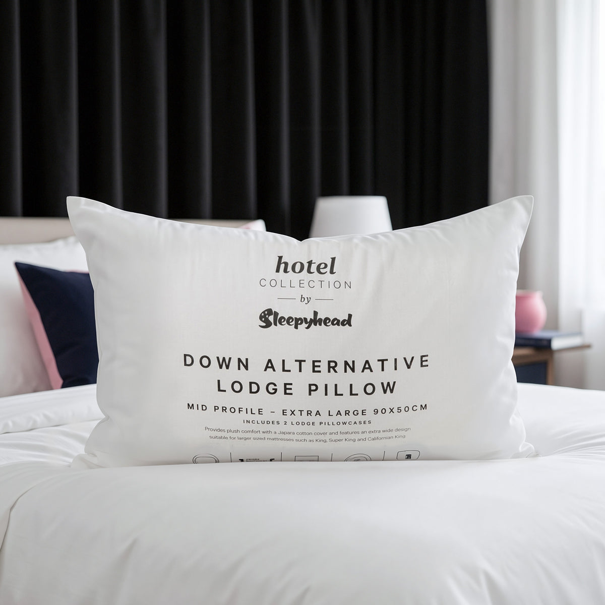 Down alternative lodge pillow with 'Hotel Collection by Sleepyhead' branding on a bed.