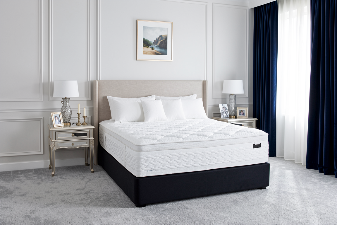 White Sleepyhead Sanctuary mattress on a bed frame in a bedroom setting with decor elements.