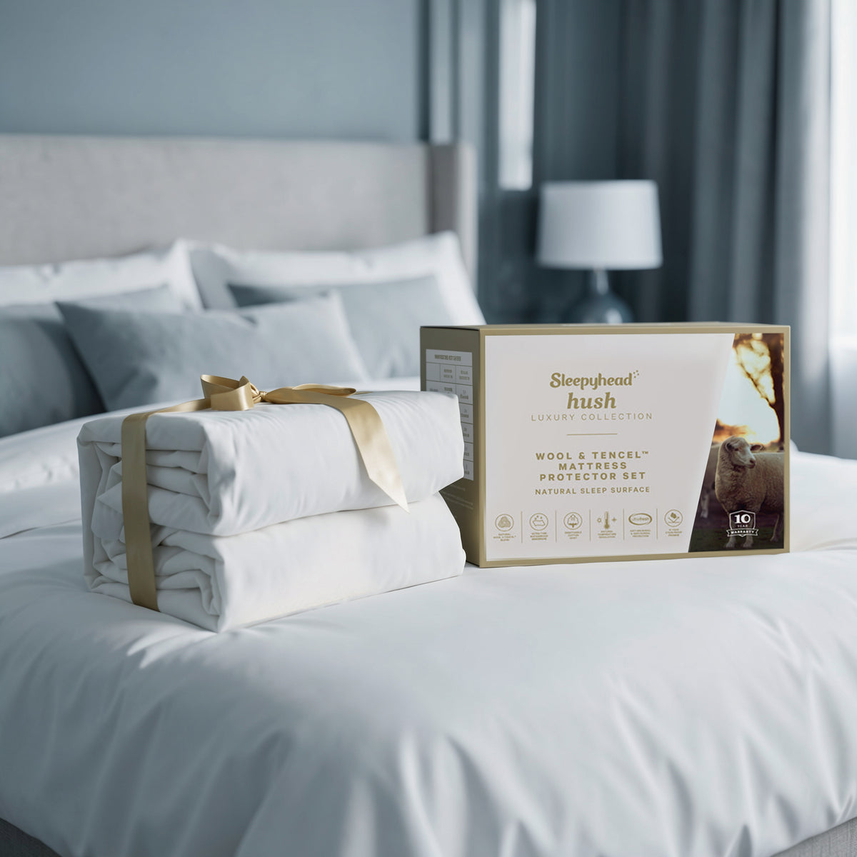 Sleepyhead Hush Wool & Tencel mattress protector set on a bed with packaging in the foreground.