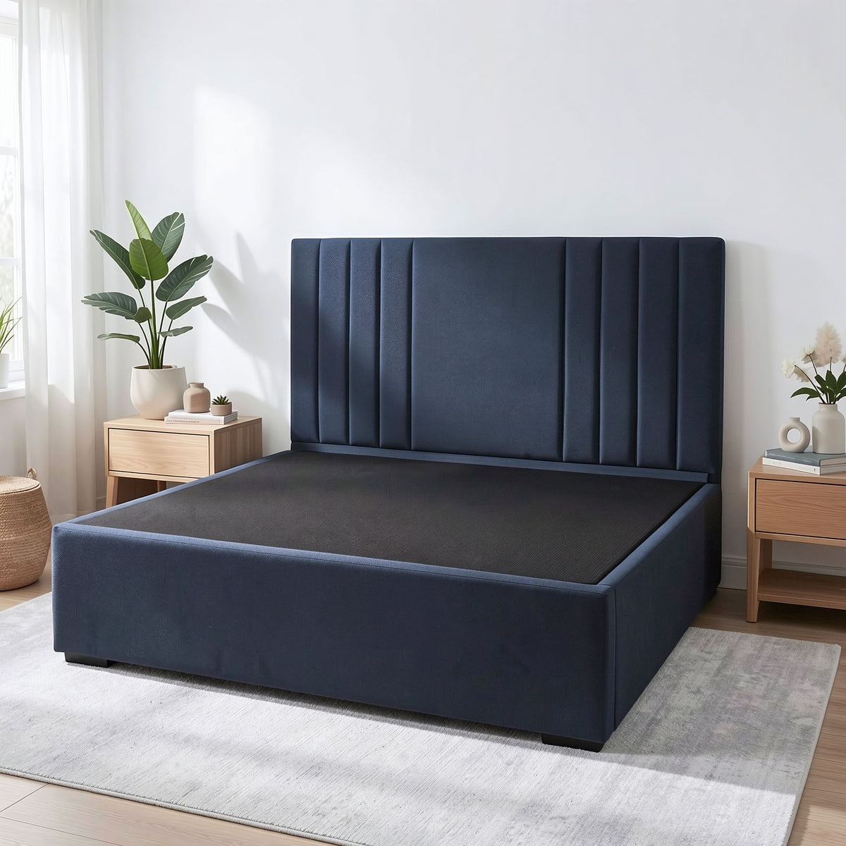 Navy blue upholstered Sleepyhead Sanctuary bed base in a room with wooden nightstands and plants.