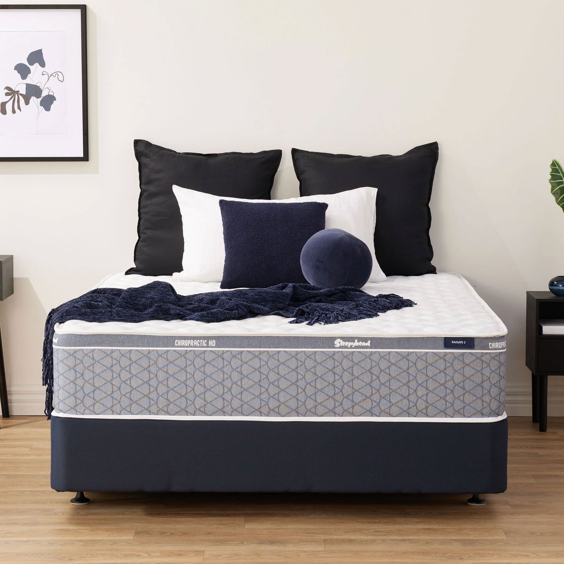 Sleepyhead Chiropractic mattress with decorative pillows and blanket in a bedroom setting