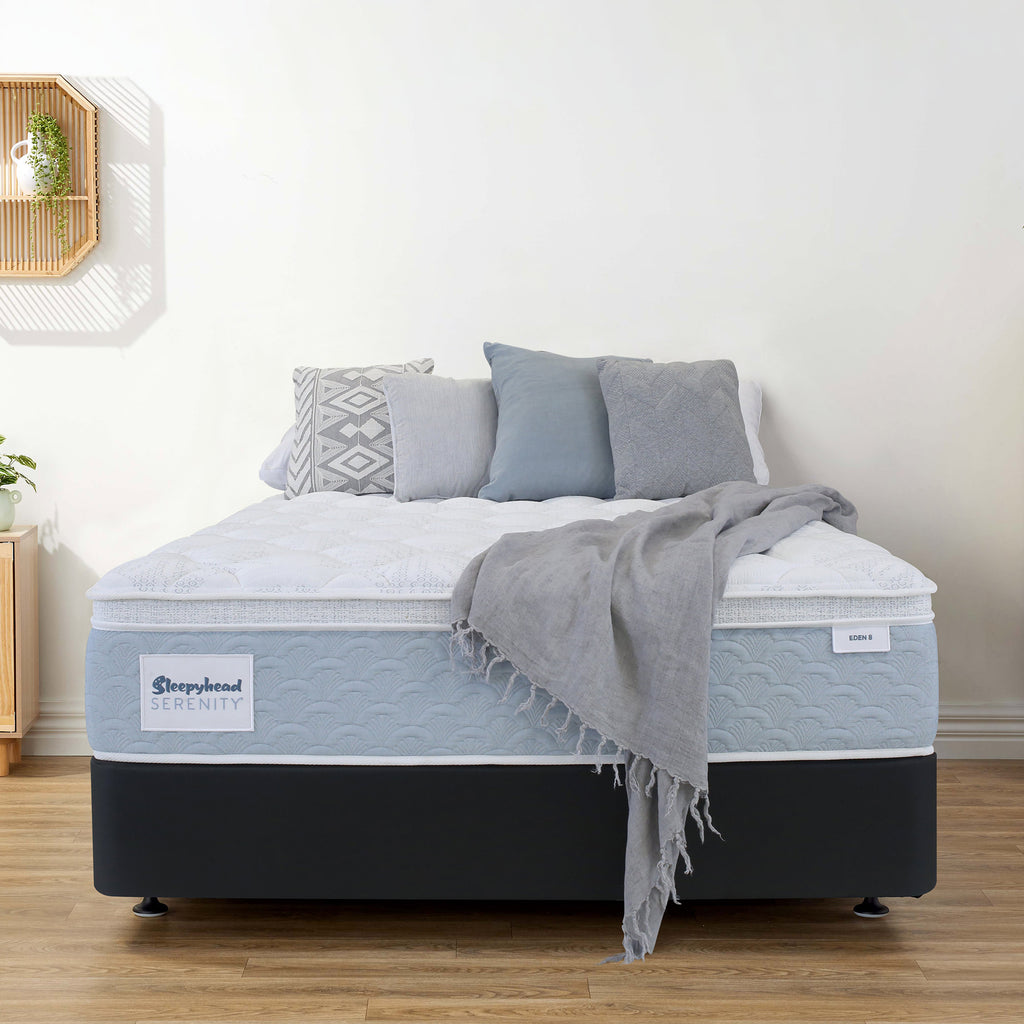 Sleepyhead Serenity mattress with gray bedding and pillows in a room setting.