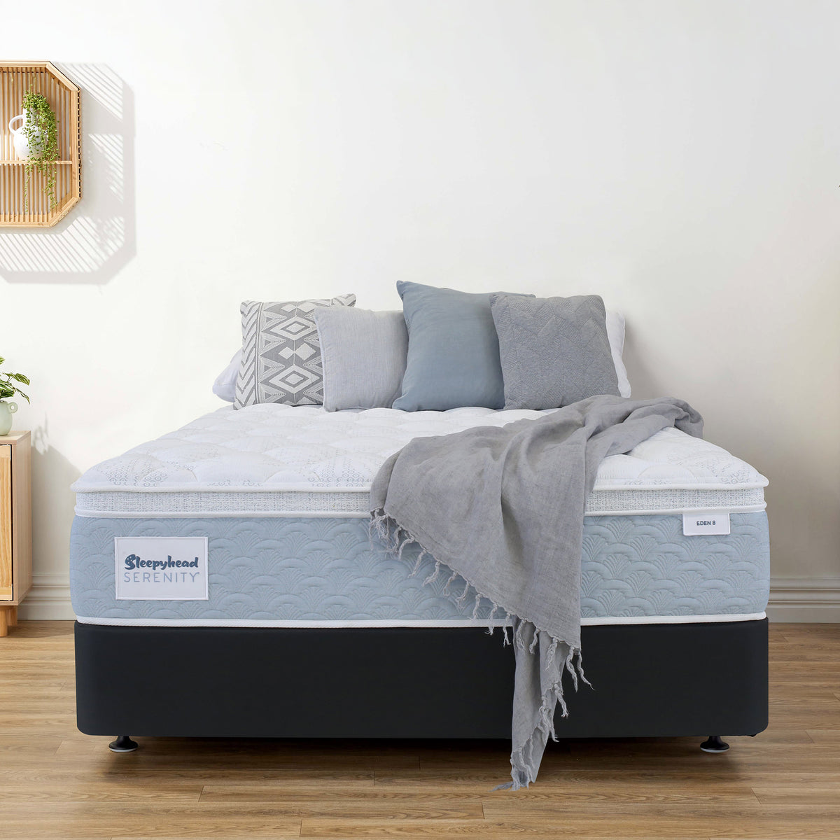 Sleepyhead Serenity mattress with gray bedding and pillows in a room setting.