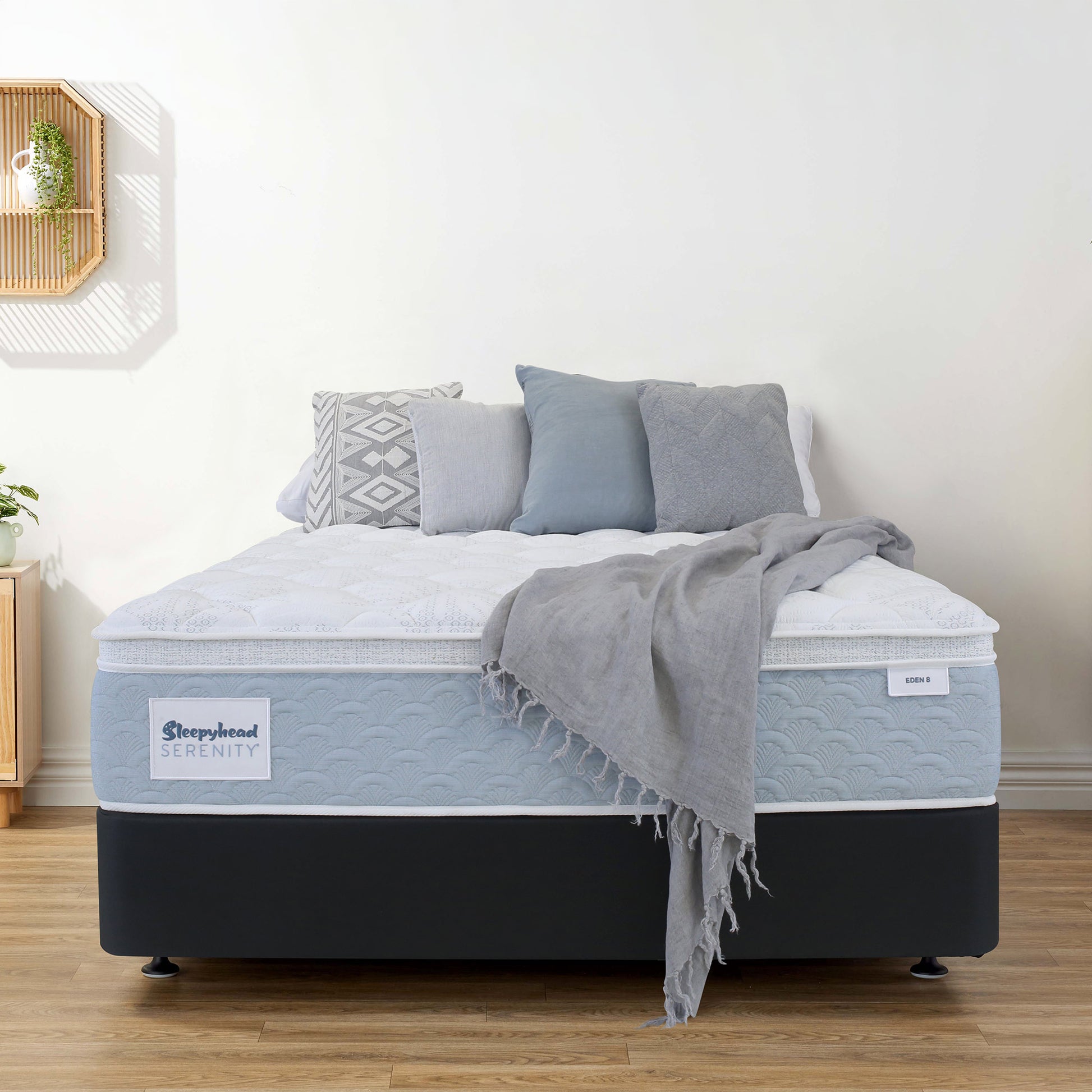 Sleepyhead Serenity mattress with gray bedding and pillows in a room setting.