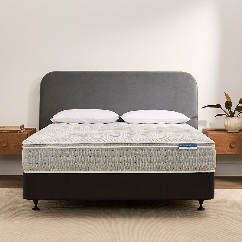 Slumbertime mattress on a bed with a gray headboard in a room setting