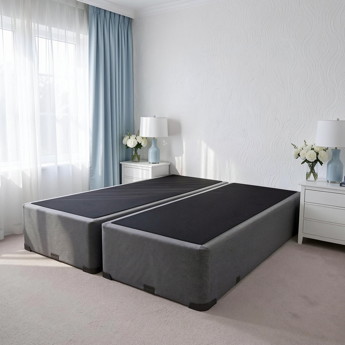 Two Sleepyhead bed bases in a bedroom setting with white walls and light blue curtains.